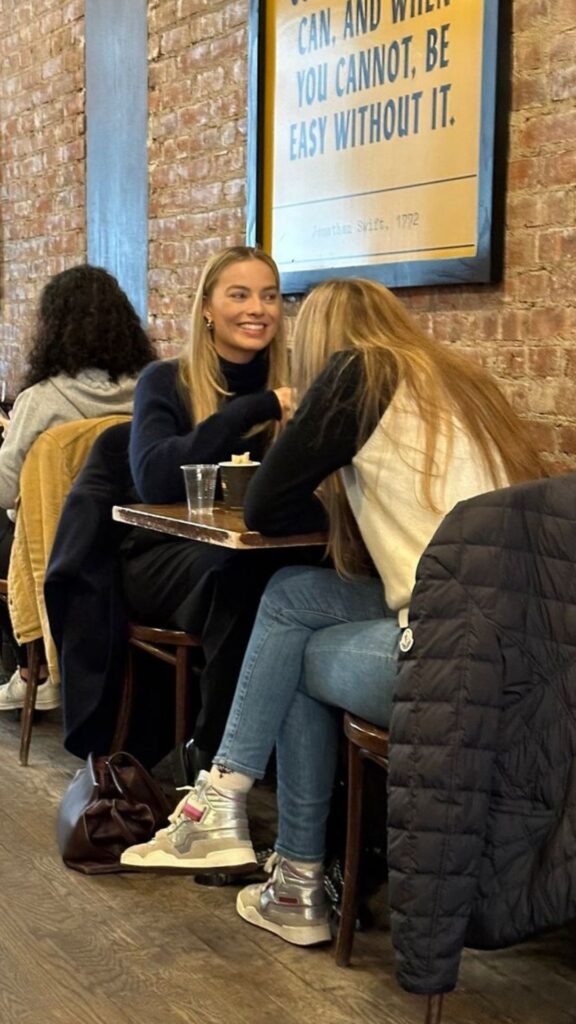 Margot Robbie facing someone who appears to be ACOTAR author Sarah J. Maas.