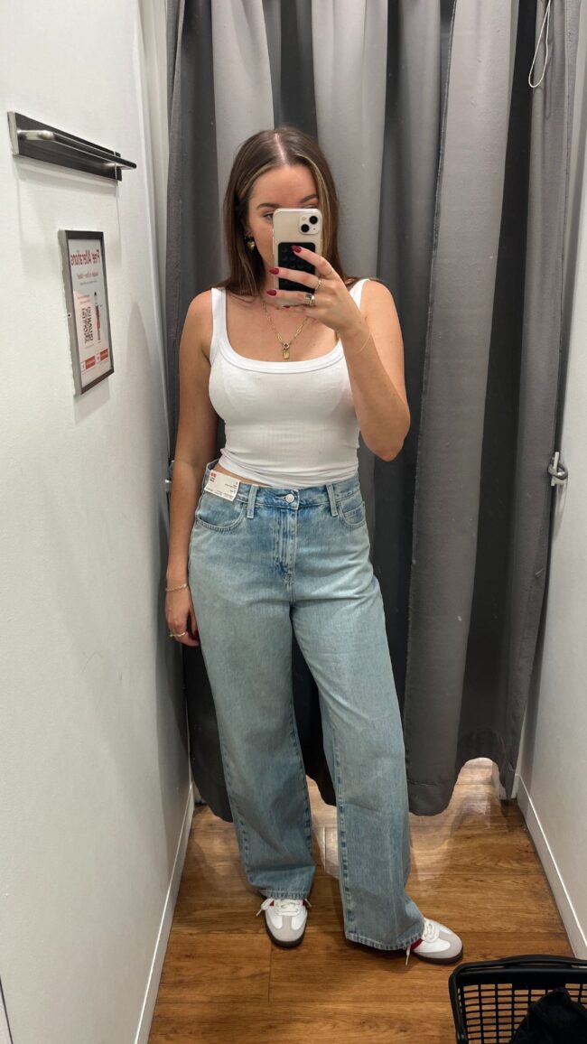 woman wears blue jeans and white tank