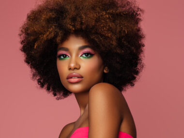 beautiful afro woman with bright makeup on pink background