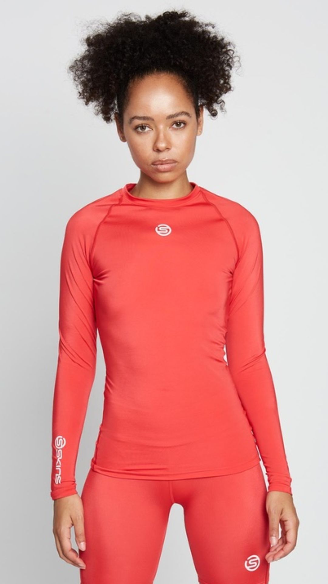 a woman with a curly high ponytail wears a red Long-sleeve Womens Activewear Top