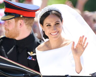 prince harry and meghan markle on their wedding day. The pair sit in a carriage and meghan waves at the camera