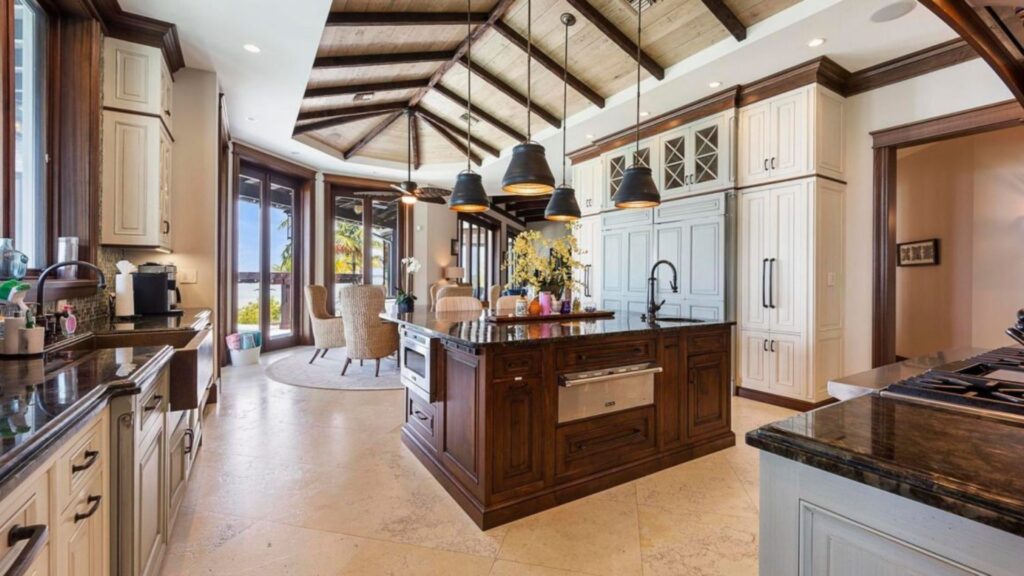 The luxurious kitchen features a kitchen island and high ceilings. 