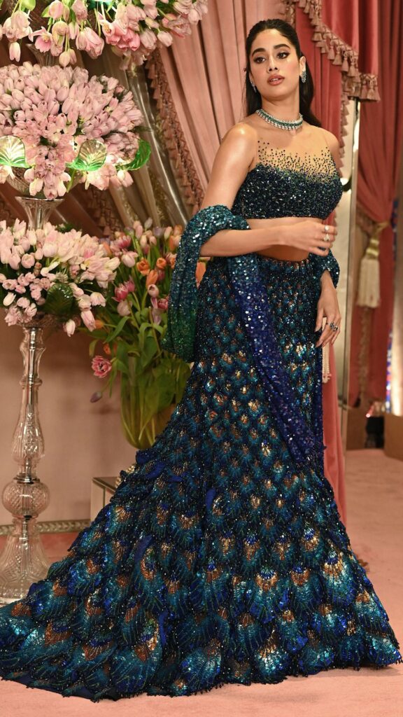 Bollywood actress Jahnvi Kapoor poses for a photo during the Sangeet Ceremony of Anant Ambani and Radhika Merchant wearing a peakock patterned gown