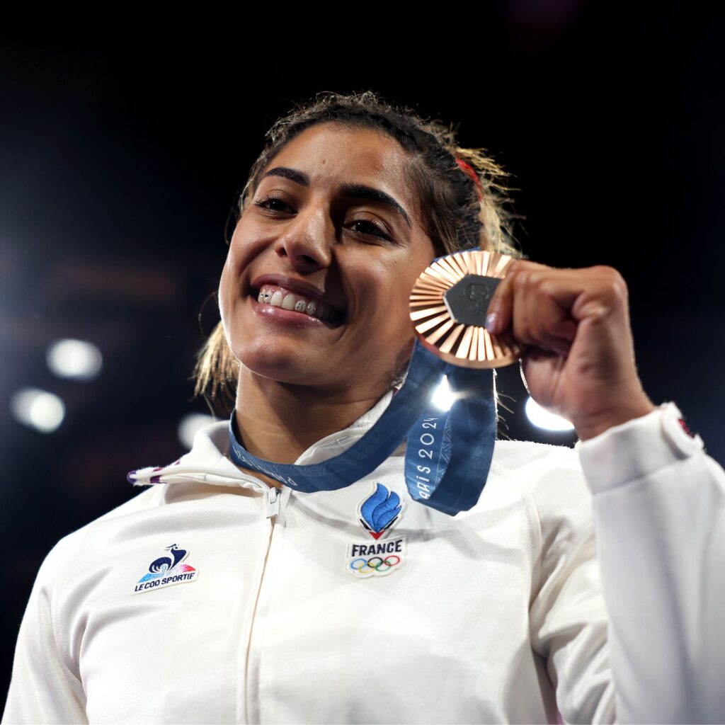 Bronze medalist Shirine Boukli of Team France celebrates on the podium during the Women -48 kg medal ceremony on day one of the Olympic Games Paris 2024 at Champs-de-Mars Arena on July 27, 2024 in Paris, France