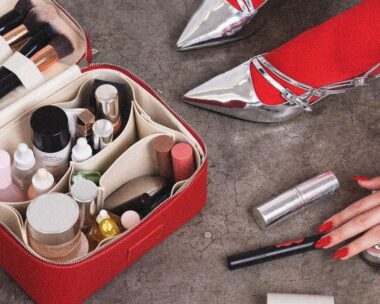 A woman with red stockings and silver heels packs her ultimate travel case for toiletries.