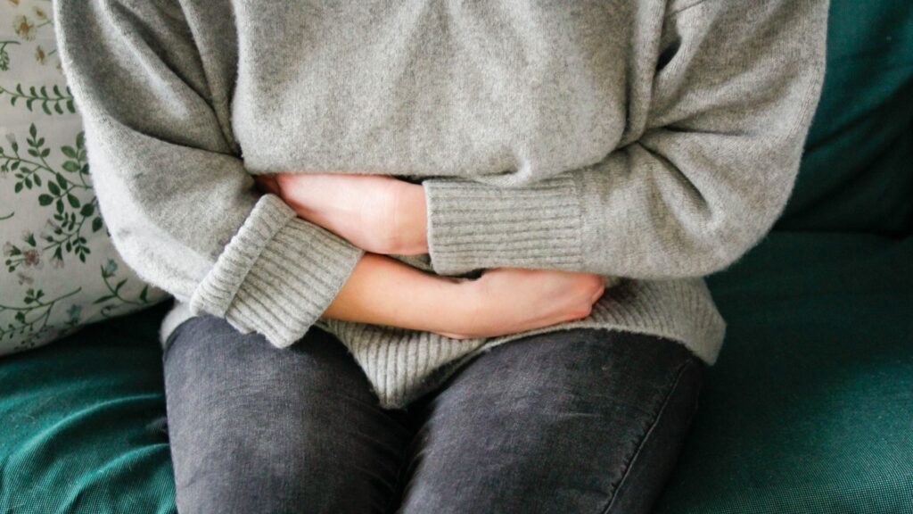 woman in pain clutching abdomen