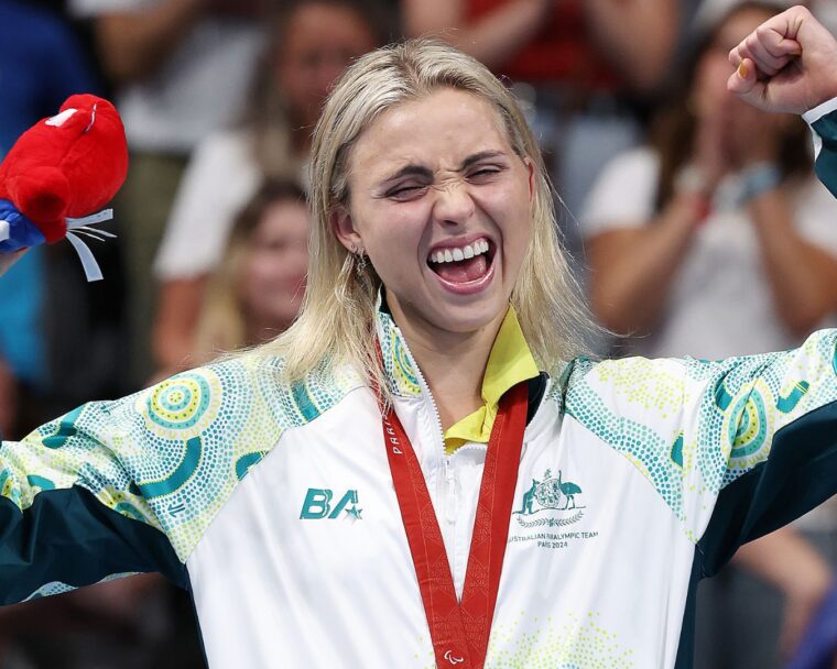 Australian para swimmer Alexa Leary celebrates on the podium after winning gold in the women's 100 metre freestyle.