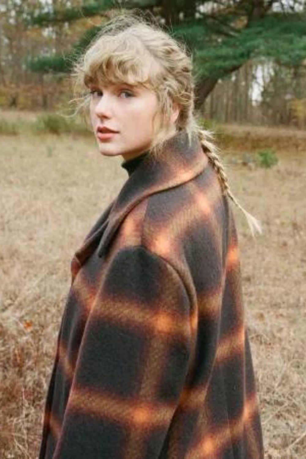 Taylor Swift in a brown coat, with a single braid for Evermore, released in December 2020.