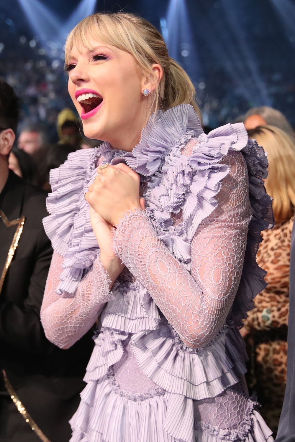 Taylor Swift in a lilac dress and pink lipstick.