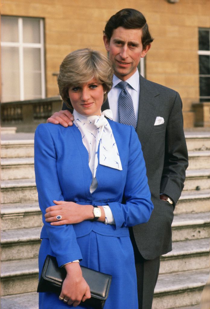 reveals her sapphire and diamond engagement ring while she and Prince Charles, Prince of Wales pose for photographs in the grounds of Buckingham Palace following the announcement of their engagement